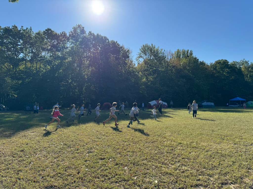 Scouts playing on a sunny field at family camp